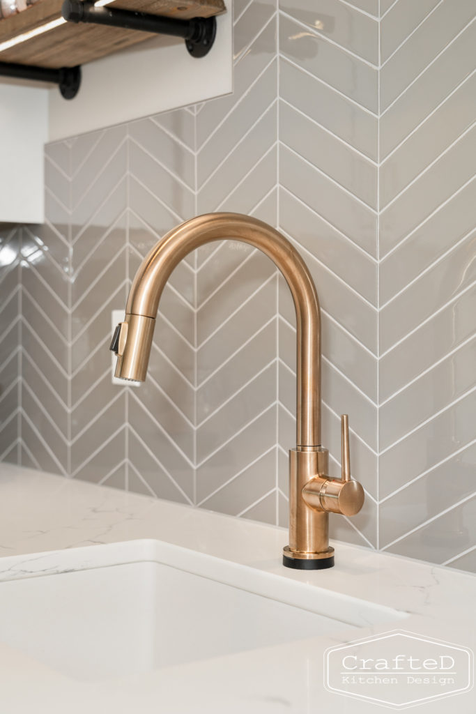 gold delta trinsic faucet in pantry kitchen with floating shelves