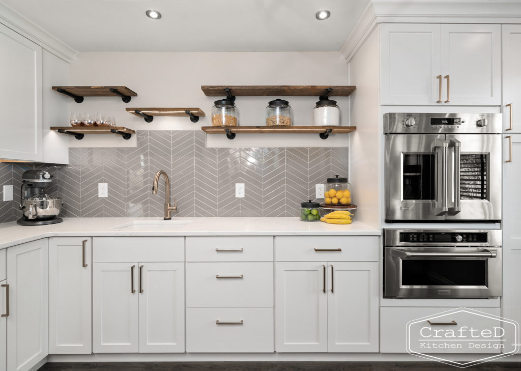 gold delta trinsic faucet in pantry kitchen with floating shelves and french door wall oven with microwave drawer