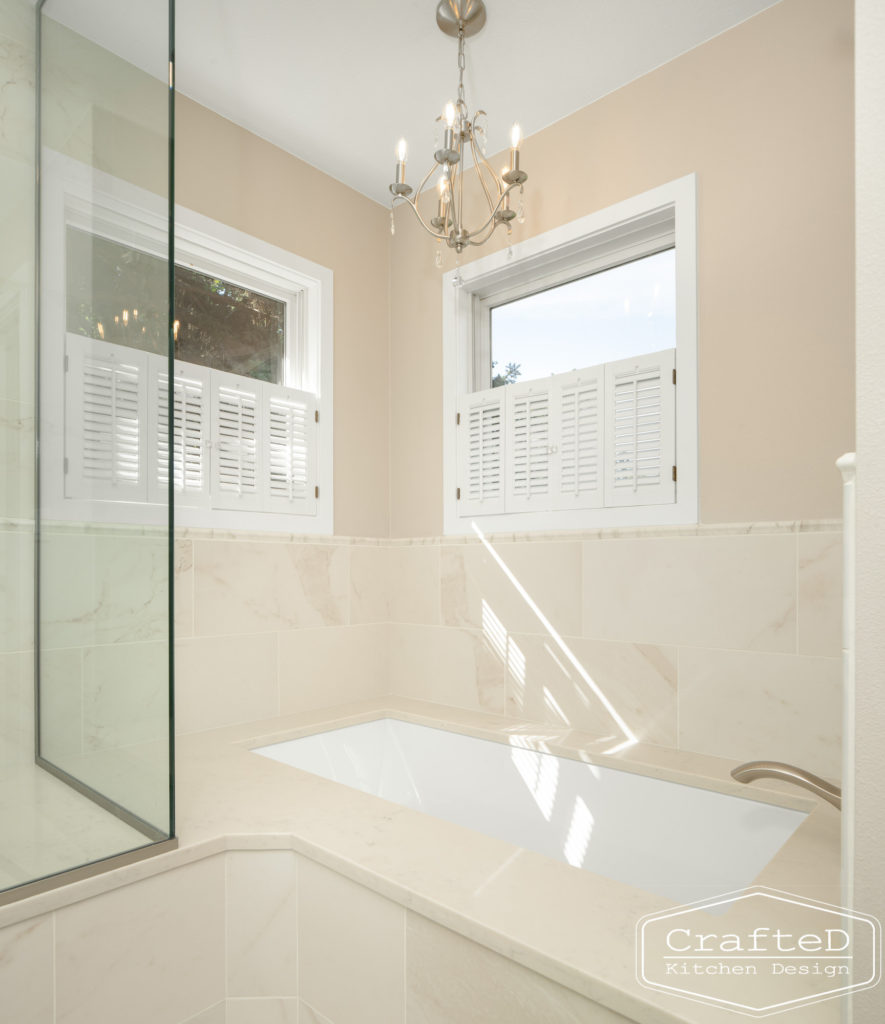 master bathroom remodel spa like with grey cabinets open shower and built in tub and chandelier above