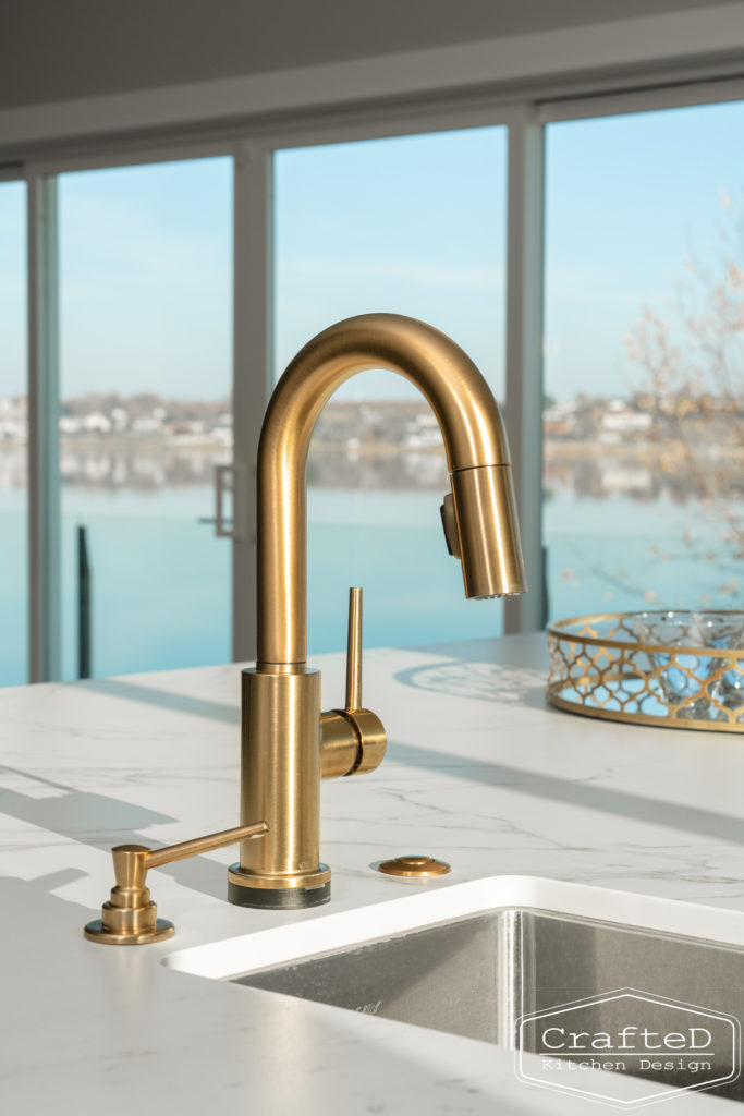 modern metropolitan kitchen design with dark toned wood cabinets, dekton marble backsplash and gold accents in spokane Coeur d'alene moses lake home renovation gold delta trinsic faucet