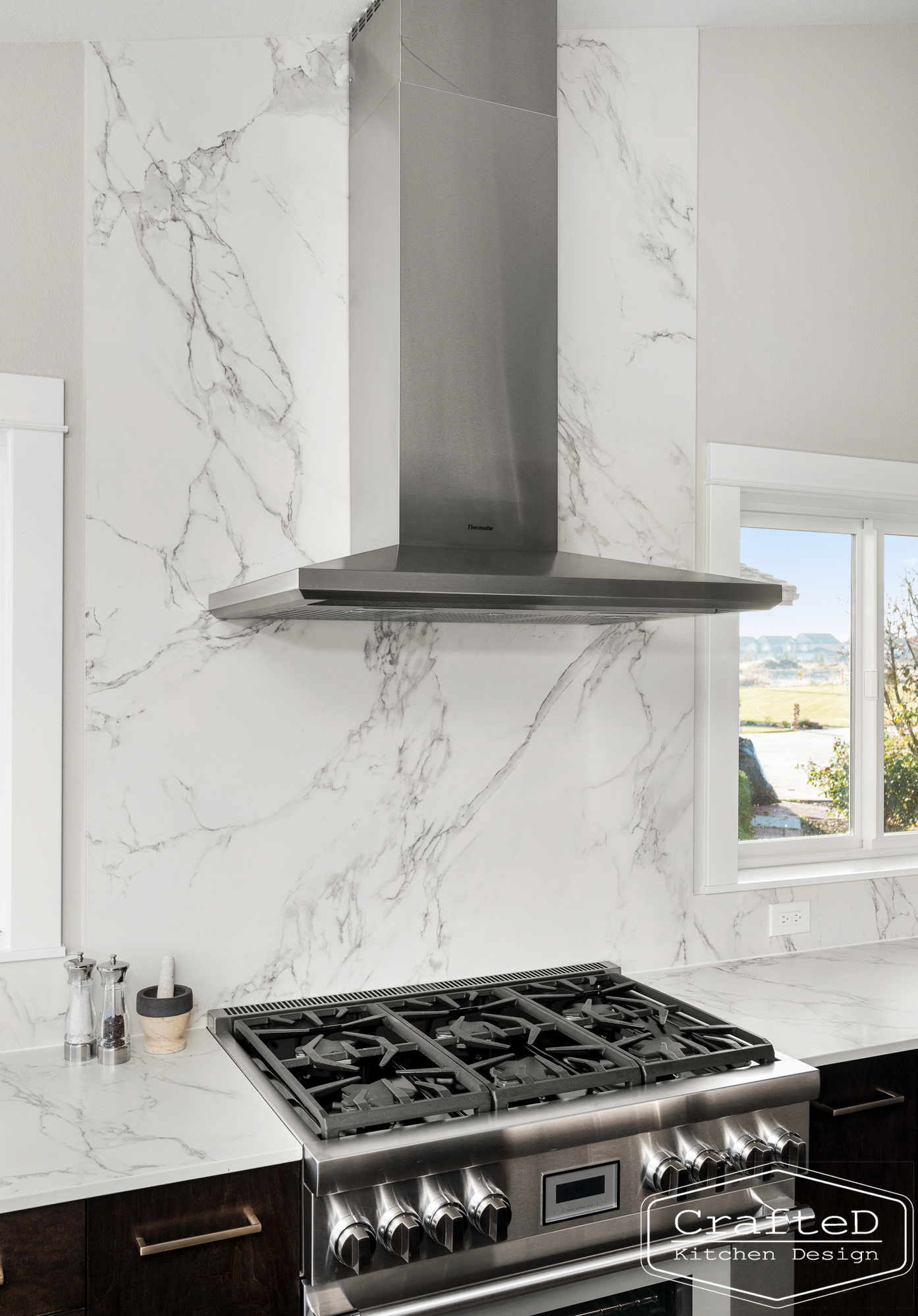 modern metropolitan kitchen design with dark toned wood cabinets, dekton marble backsplash and gold accents in spokane Coeur d'alene moses lake home renovation