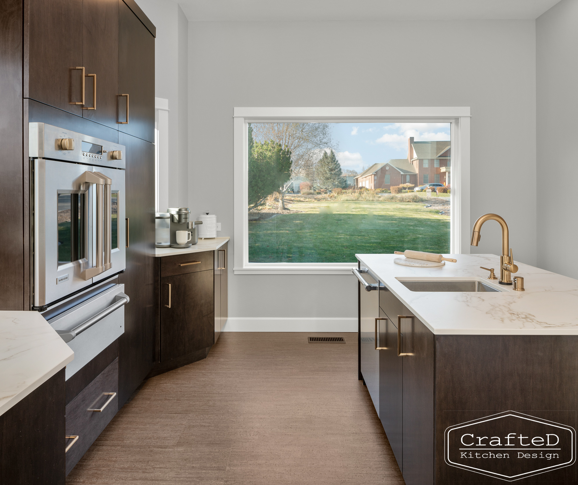 modern metropolitan kitchen design with dark toned wood cabinets, dekton marble backsplash and gold accents in spokane Coeur d'alene moses lake home renovation