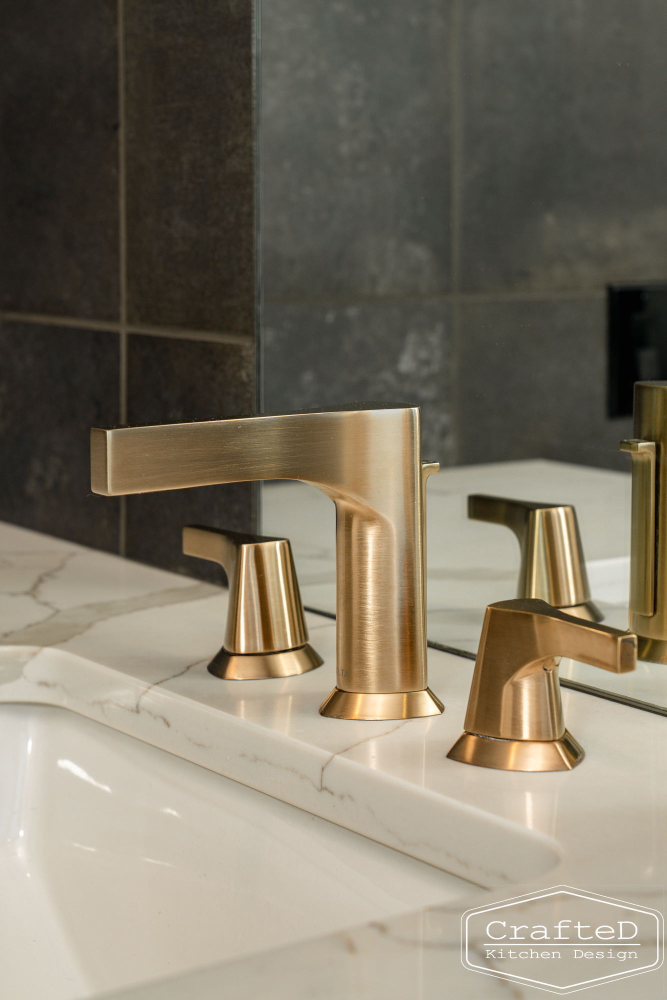 modern metropolitan bathroom design with dark toned wood cabinets, dekton marble backsplash and gold accents in spokane Coeur d'alene moses lake home renovation with delta faucet