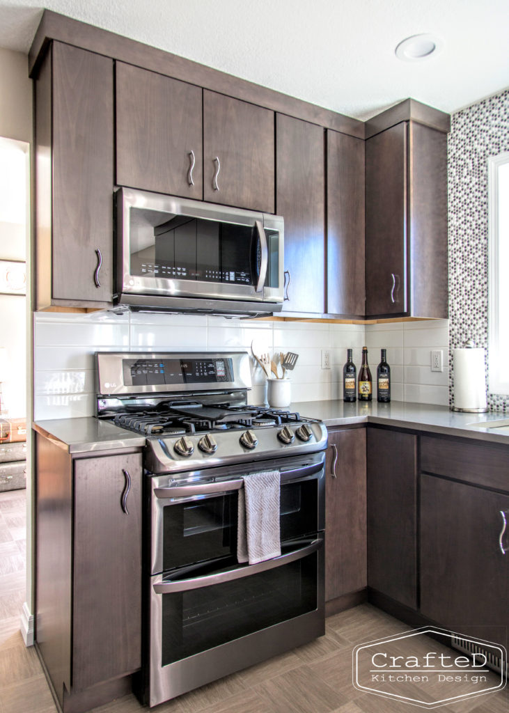 dark wood kitchen cabinets with lvp flooring and penny tile backsplash design