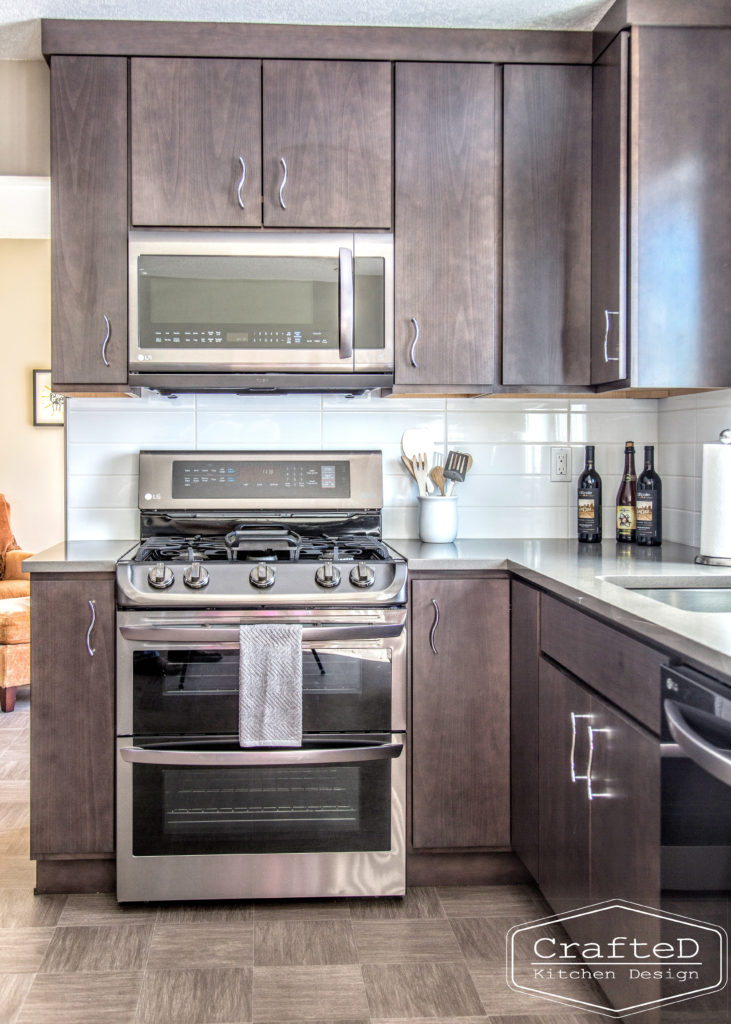 dark wood kitchen cabinets with lvp flooring and penny tile backsplash design