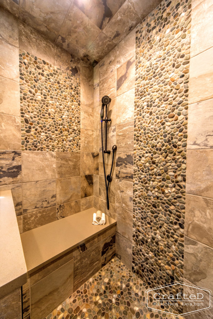 pebblies inspired bathroom remodel with wood cabinets and warm accent tile