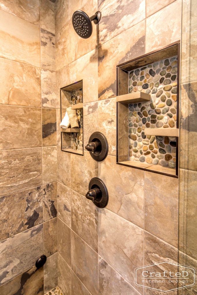 pebblies inspired bathroom remodel with wood cabinets and warm accent tile