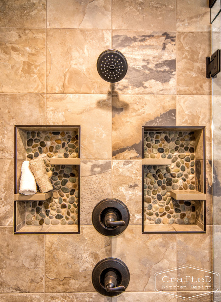 pebblies inspired bathroom remodel with wood cabinets and warm accent tile