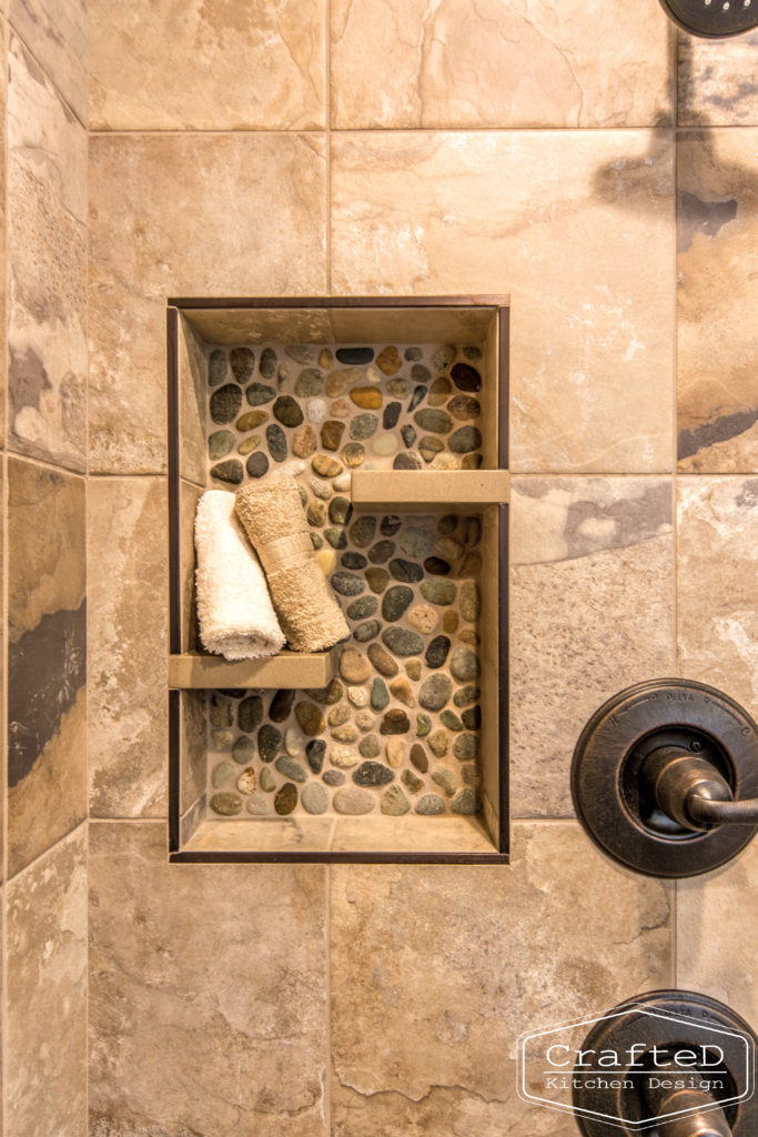 pebblies inspired bathroom remodel with wood cabinets and warm accent tile